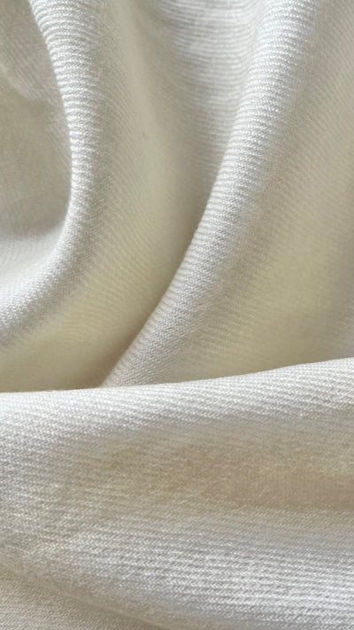 A close-up image of a merino wool fabric showing its texture and natural color.