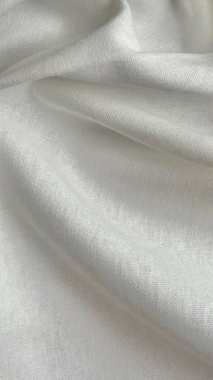 A close-up view of a yard of white, recycled cotton woven fabric with a soft texture.